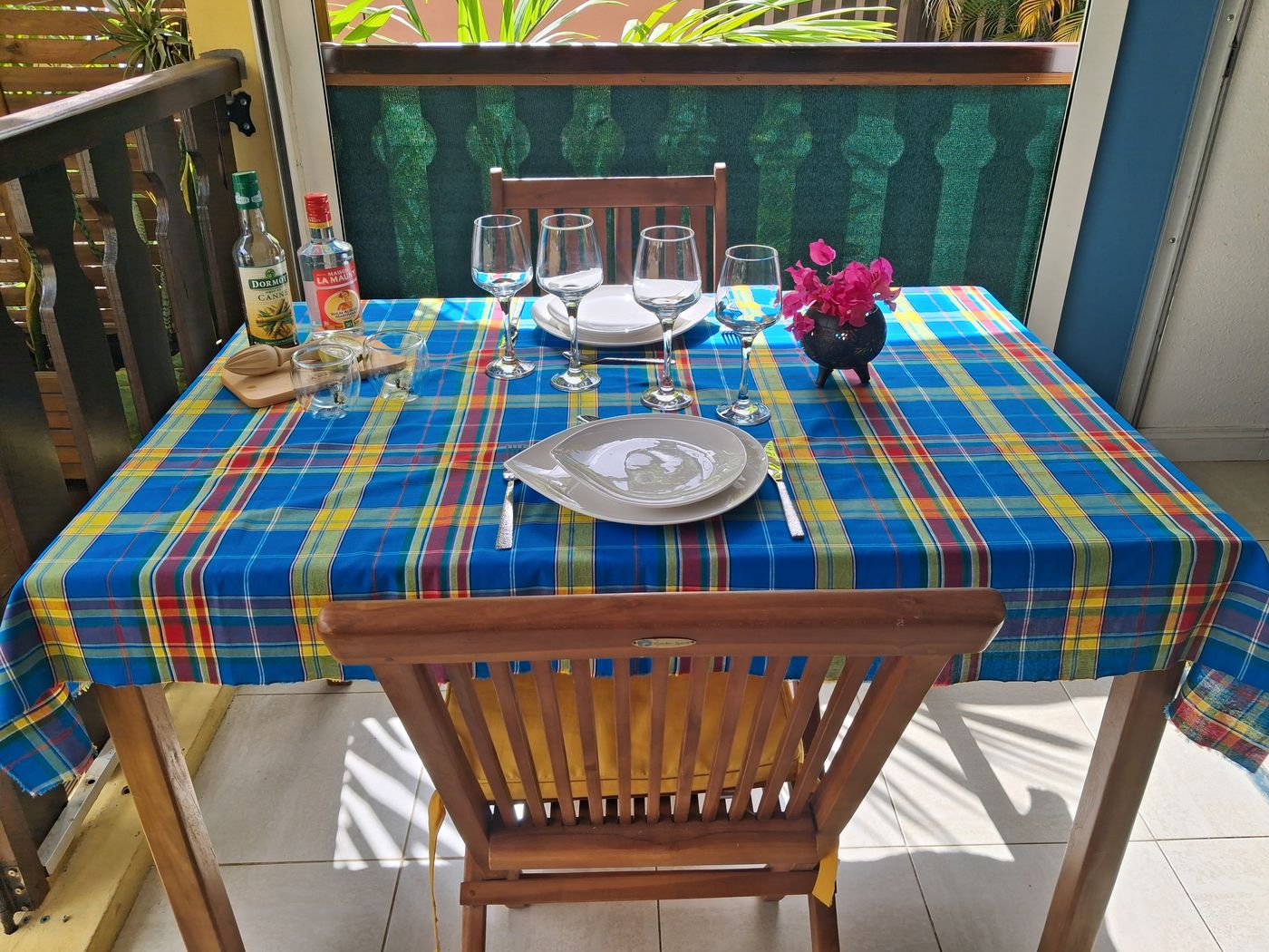 La terrasse couverte, table dressée avec sa nappe madras